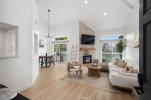 20092 Bayfront Ln Unit 206, Huntington Beach, CA 92646 - living area with high vaulted ceiling, a large fireplace, plenty of natural light, light wood-type flooring, and a chandelier