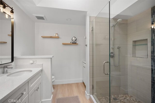 20092 Bayfront Ln Unit 206, Huntington Beach, CA 92646 - bathroom featuring wood finished floors, vanity, a shower stall, toilet, and baseboards