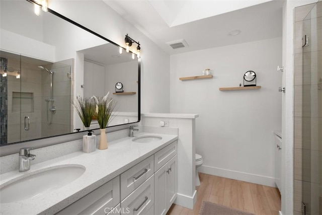 20092 Bayfront Ln Unit 206, Huntington Beach, CA 92646 - full bath with double vanity, wood finished floors, toilet, a stall shower, and baseboards