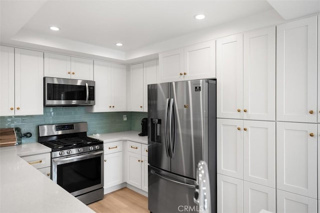 20092 Bayfront Ln Unit 206, Huntington Beach, CA 92646 - kitchen with stainless steel appliances, white cabinets, recessed lighting, decorative backsplash, and light wood-style flooring