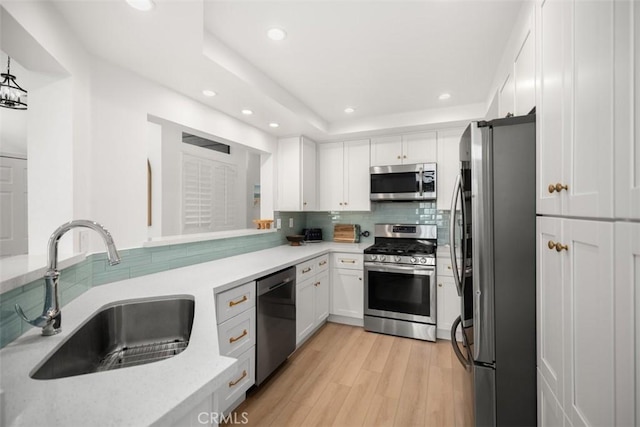 20092 Bayfront Ln Unit 206, Huntington Beach, CA 92646 - kitchen with appliances with stainless steel finishes, a sink, white cabinets, recessed lighting, and decorative backsplash