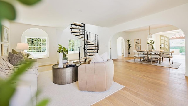 3728 Wawona Dr, San Diego, CA 92107 - living area featuring arched walkways, stairway, light wood finished floors, and baseboards