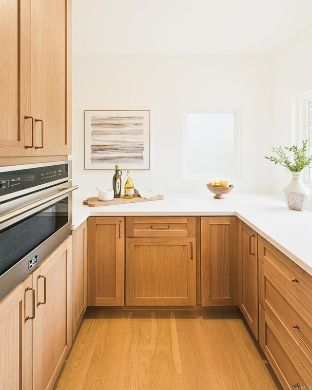 3728 Wawona Dr, San Diego, CA 92107 - kitchen with stainless steel oven, light wood-style floors, and light countertops