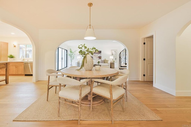 3728 Wawona Dr, San Diego, CA 92107 - dining space featuring light wood finished floors, arched walkways, and baseboards