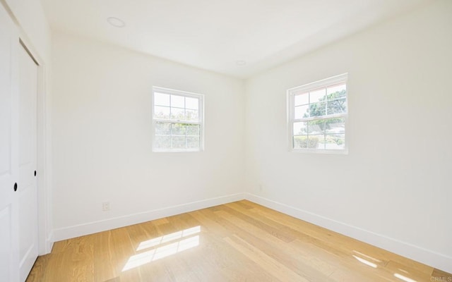 3728 Wawona Dr, San Diego, CA 92107 - unfurnished bedroom with multiple windows, light wood-style floors, baseboards, and a closet