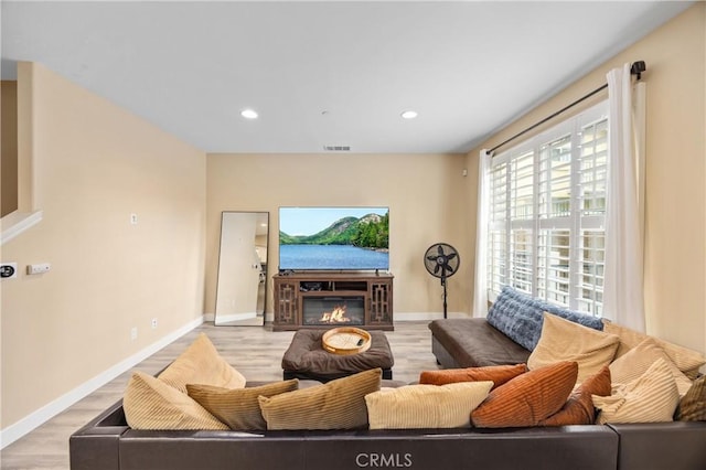 11437 Excelsior Dr Unit C, Norwalk, CA 90650 - living room featuring light wood-style flooring, baseboards, recessed lighting, and a glass covered fireplace