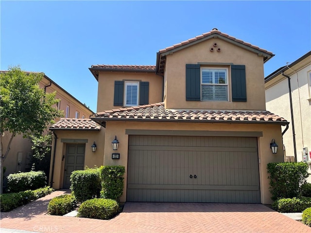 123 Windham, Irvine, CA 92620 - mediterranean / spanish house featuring a tile roof, an attached garage, decorative driveway, and stucco siding
