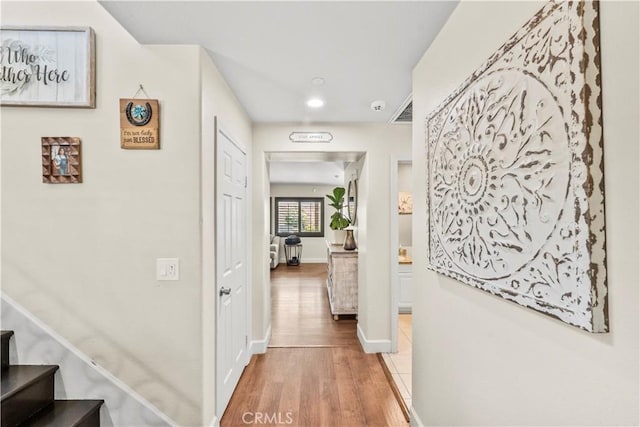 7925 Hemingway Ct, Fontana, CA 92336 - hallway with wood finished floors, stairs, baseboards, and recessed lighting