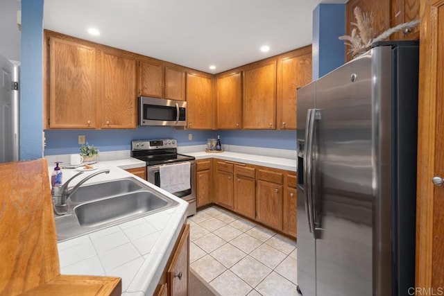 7398 Park View Ct Unit 135, Santee, CA 92071 - kitchen featuring appliances with stainless steel finishes, a sink, light tile patterned floors, brown cabinetry, and recessed lighting