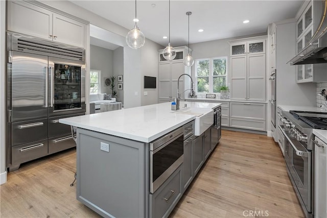 8126 Santaluz Village N, San Diego, CA 92127 - kitchen featuring built in appliances, a sink, wall chimney range hood, gray cabinetry, and recessed lighting