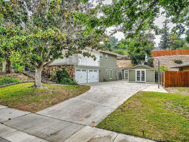 1169 Lyndhurst Dr, Riverside, CA 92507 - view of front of home with driveway, an attached garage, stone siding, and an outbuilding