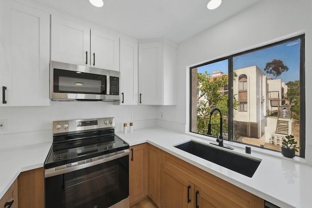 1915 Via Las Palmas Unit 32A, National City, CA 91950 - kitchen featuring appliances with stainless steel finishes, a sink, light countertops, white cabinets, and recessed lighting