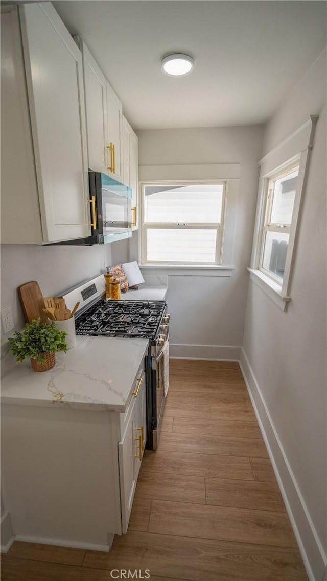 1520 Ohio Ave, Long Beach, CA 90804 - kitchen with gas stove, light wood-type flooring, baseboards, white cabinets, and light stone countertops