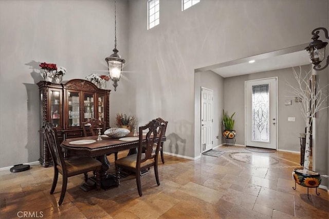 23501 Brigin Pl, Murrieta, CA 92562 - dining room featuring stone tile flooring, baseboards, and a towering ceiling