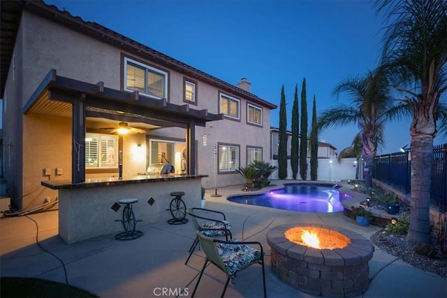 23501 Brigin Pl, Murrieta, CA 92562 - pool at twilight featuring a bar, a fenced backyard, a fire pit, a patio area, and area for grilling