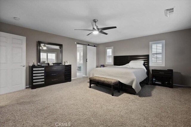 23501 Brigin Pl, Murrieta, CA 92562 - carpeted bedroom featuring multiple windows, a barn door, and a ceiling fan