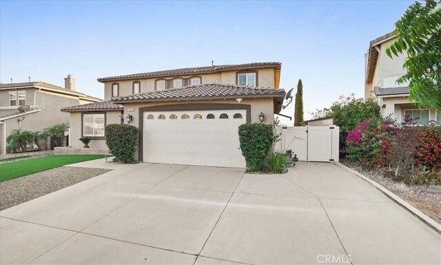 23501 Brigin Pl, Murrieta, CA 92562 - mediterranean / spanish house with a gate, an attached garage, stucco siding, concrete driveway, and a tiled roof