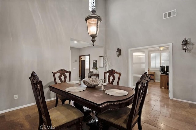 23501 Brigin Pl, Murrieta, CA 92562 - dining space with a high ceiling, stone tile flooring, baseboards, and plenty of natural light