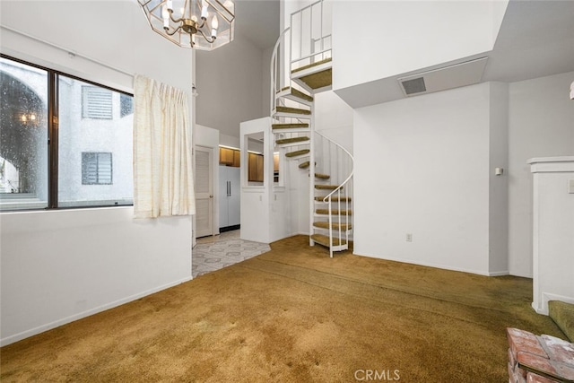 17202 Corbina Ln Unit 206, Huntington Beach, CA 92649 - unfurnished living room featuring light colored carpet, stairs, a chandelier, baseboards, and a high ceiling