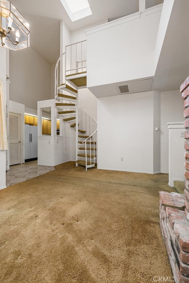17202 Corbina Ln Unit 206, Huntington Beach, CA 92649 - unfurnished living room with stairs, a towering ceiling, light colored carpet, and a skylight