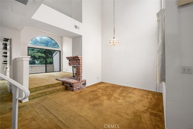 17202 Corbina Ln Unit 206, Huntington Beach, CA 92649 - unfurnished living room featuring carpet, a high ceiling, a brick fireplace, and stairway