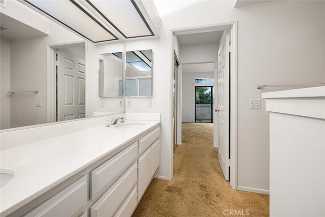 17202 Corbina Ln Unit 206, Huntington Beach, CA 92649 - bathroom with double vanity, carpet floors, and baseboards