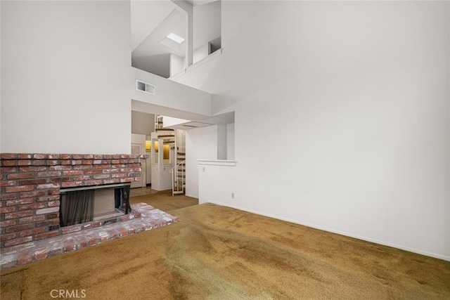 17202 Corbina Ln Unit 206, Huntington Beach, CA 92649 - unfurnished living room with carpet floors, stairway, a brick fireplace, a high ceiling, and baseboards