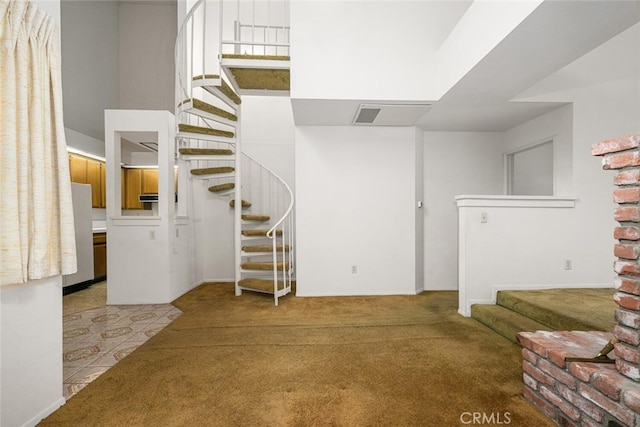 17202 Corbina Ln Unit 206, Huntington Beach, CA 92649 - unfurnished living room with stairs, carpet flooring, a high ceiling, and baseboards