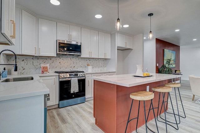 1320 Vinca Way, San Diego, CA 92114 - kitchen featuring appliances with stainless steel finishes, a sink, light wood finished floors, tasteful backsplash, and light stone counters
