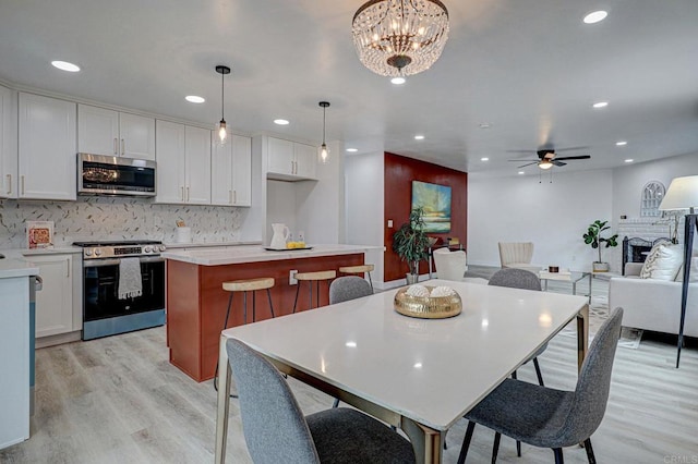 1320 Vinca Way, San Diego, CA 92114 - dining space with light wood-style flooring, ceiling fan, recessed lighting, a fireplace, and a chandelier