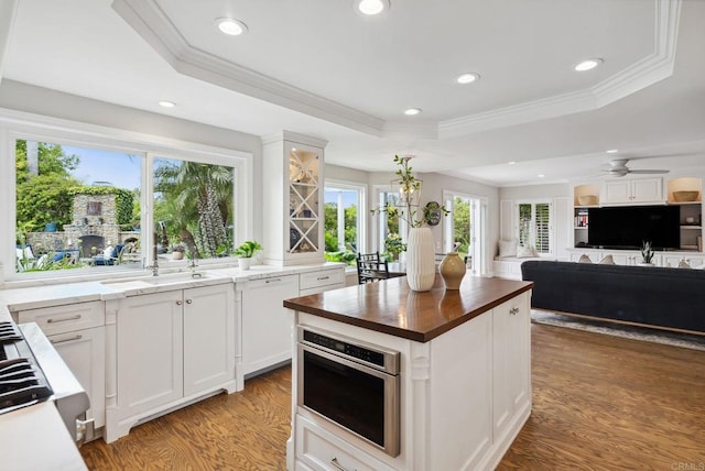 3686 Landfair Ct, San Diego, CA 92130 - kitchen featuring wood counters, a raised ceiling, a sink, light wood-style flooring, and crown molding