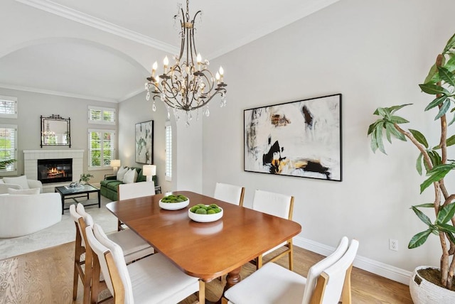 3686 Landfair Ct, San Diego, CA 92130 - dining space featuring wood finished floors, crown molding, a glass covered fireplace, and baseboards