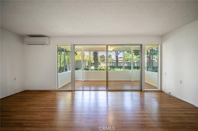 270 Avenida Sevilla Unit C, Laguna Woods, CA 92637 - unfurnished room with an AC wall unit, wood finished floors, and a textured ceiling