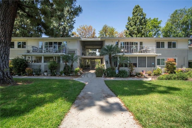 270 Avenida Sevilla Unit C, Laguna Woods, CA 92637 - view of front of property with stucco siding, a front lawn, and a balcony