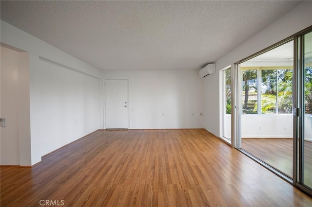 270 Avenida Sevilla Unit C, Laguna Woods, CA 92637 - empty room featuring wood finished floors, a textured ceiling, and a wall mounted AC