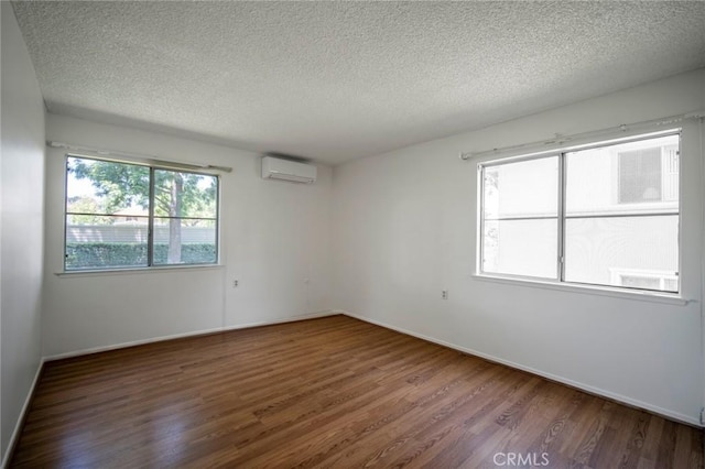 270 Avenida Sevilla Unit C, Laguna Woods, CA 92637 - unfurnished room featuring a wall mounted AC, a textured ceiling, wood finished floors, and baseboards