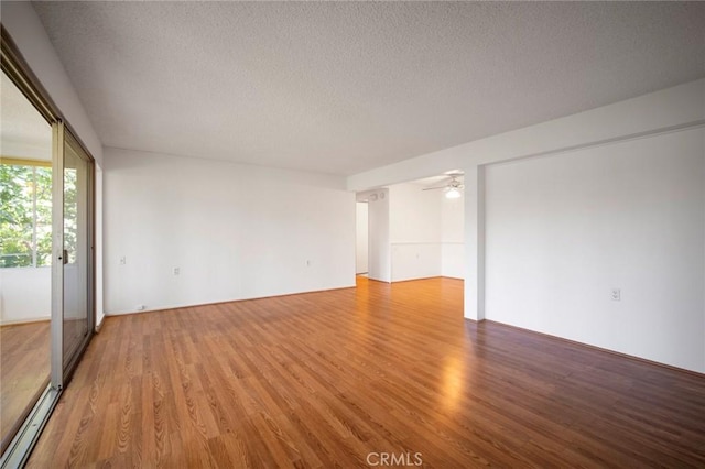 270 Avenida Sevilla Unit C, Laguna Woods, CA 92637 - empty room featuring a textured ceiling, light wood-style floors, ceiling fan, and a baseboard heating unit
