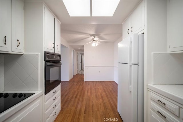 270 Avenida Sevilla Unit C, Laguna Woods, CA 92637 - kitchen featuring black appliances, a ceiling fan, white cabinetry, and decorative backsplash