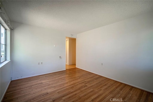 270 Avenida Sevilla Unit C, Laguna Woods, CA 92637 - empty room with wood finished floors, a textured ceiling, and baseboards