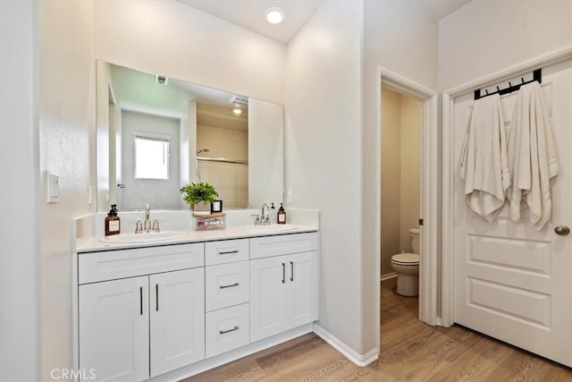 11653 Couples Ct, Beaumont, CA 92223 - full bath with wood finished floors, toilet, double vanity, and an enclosed shower