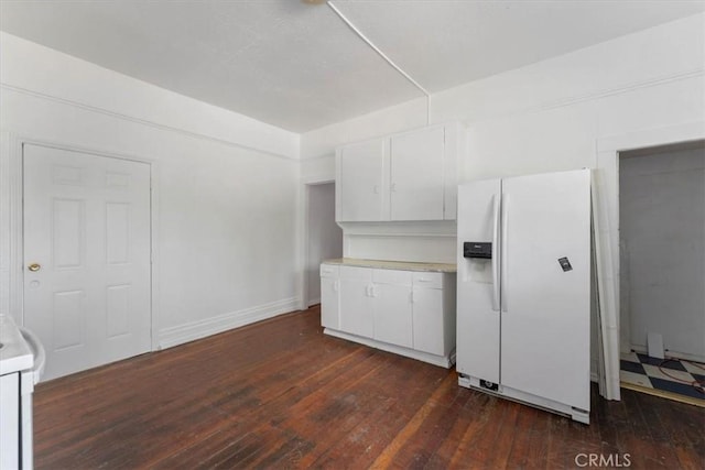 818 6th St, Corning, CA 96021 - kitchen with white fridge with ice dispenser, light countertops, white cabinetry, and dark wood-style floors