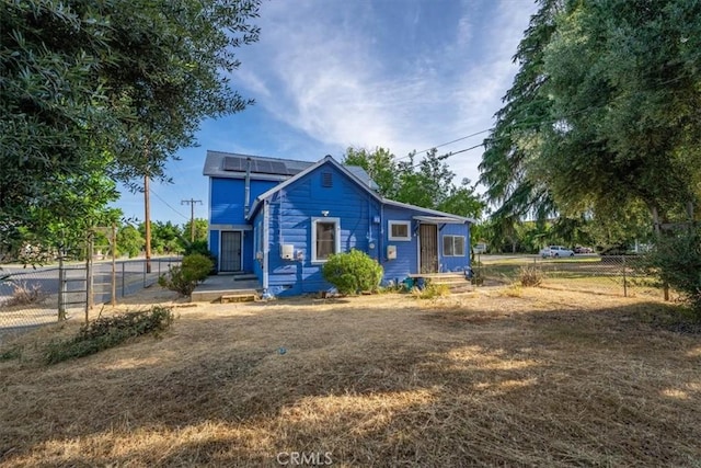 818 6th St, Corning, CA 96021 - view of front of house with roof mounted solar panels and a fenced backyard