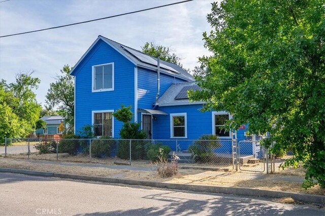 818 6th St, Corning, CA 96021 - view of front of property featuring roof mounted solar panels and a fenced front yard