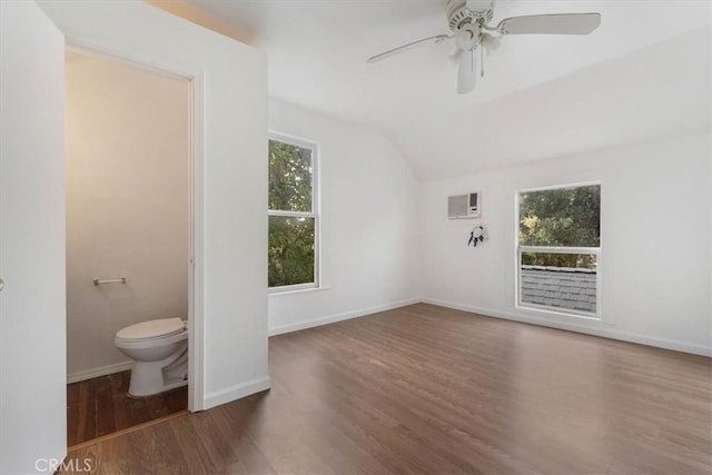 818 6th St, Corning, CA 96021 - unfurnished living room featuring lofted ceiling, wood finished floors, a wall unit AC, a ceiling fan, and baseboards