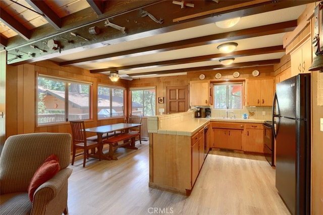 8067 Chilnualna Falls Rd, Wawona, CA 95389 - kitchen with black appliances, tile counters, light wood-style floors, a peninsula, and beam ceiling