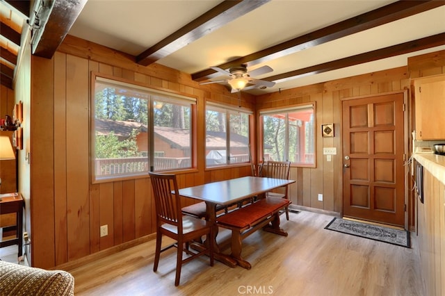 8067 Chilnualna Falls Rd, Wawona, CA 95389 - dining area featuring light wood-style floors, beamed ceiling, baseboards, ceiling fan, and wood walls