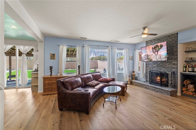 3042 San Luis Dr, Lancaster, CA 93535 - living room with a fireplace, plenty of natural light, light wood-style floors, and a ceiling fan