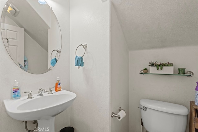 3042 San Luis Dr, Lancaster, CA 93535 - half bathroom with vaulted ceiling, toilet, a sink, and a textured ceiling