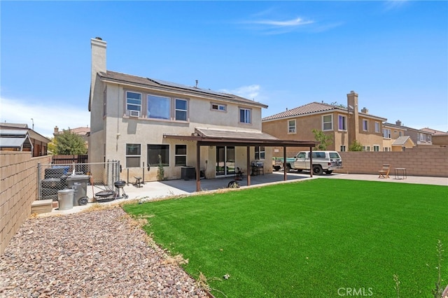 3042 San Luis Dr, Lancaster, CA 93535 - back of house with solar panels, stucco siding, a patio area, and a chimney