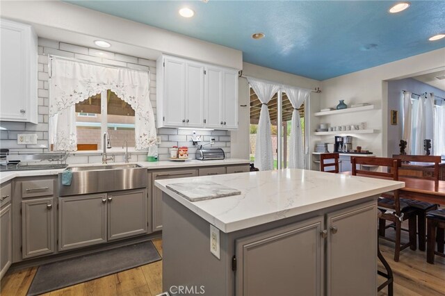 3042 San Luis Dr, Lancaster, CA 93535 - kitchen with gray cabinets, a sink, a kitchen island, wood finished floors, and recessed lighting